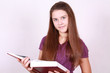 Girl of the school age keeps in hand greater book