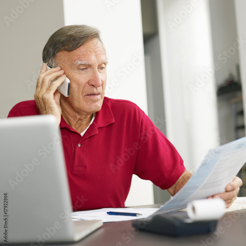 Photo: Senior man checking home finances Senior man checking home finances