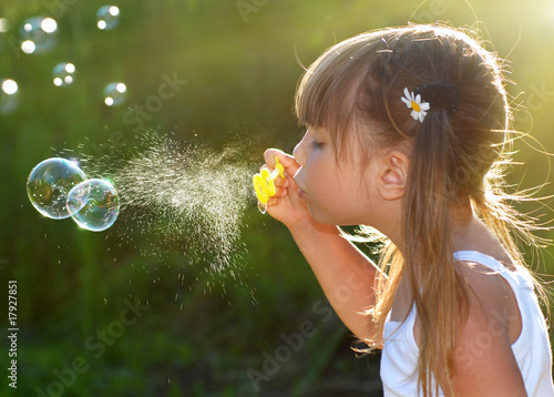 Photo: Little girl blowing soap bubbles Little girl blowing soap bubbles
