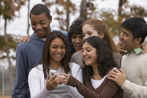 Photo: Young people looking at cell phone Young people looking at cell phone