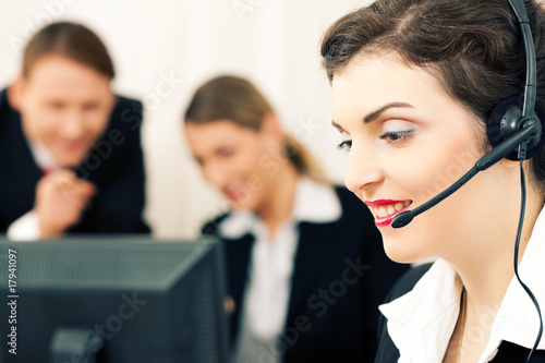 Team mit Headset und Computern