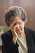 Senior Hispanic woman with head in hand