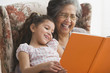 Hispanic grandmother reading to granddaughter