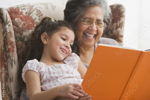Photo: Hispanic grandmother reading to granddaughter Hispanic grandmother reading to granddaughter