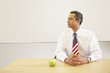 Hispanic male teacher with American flag tie and apple on desk