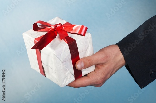 Photo: man holiday and offering a gift on his hand man holiday and offering a gift on his hand