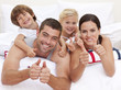Family playing in bed with thumbs up