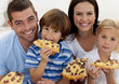 Portrait of family eating pizza in living-room
