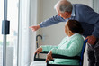 Old woman on a wheel chair , man pointing outside