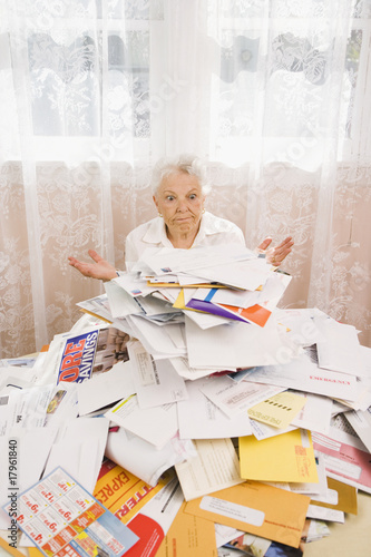 Photo: Senior woman looking at pile of bills Senior woman looking at pile of bills