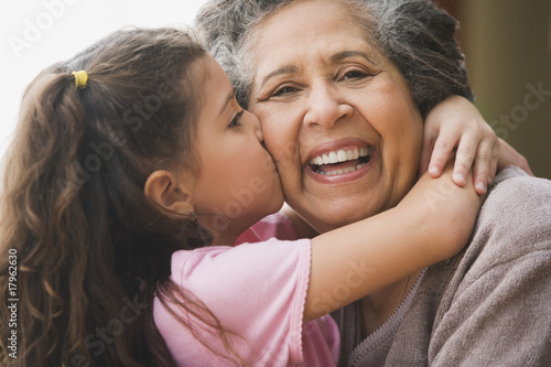 Photo: Hispanic granddaughter kissing grandmother's cheek Hispanic granddaughter kissing grandmother's cheek