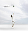 Pacific Islander woman reaching for dollar on tree