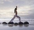 Pacific Islander woman practicing yoga at beach