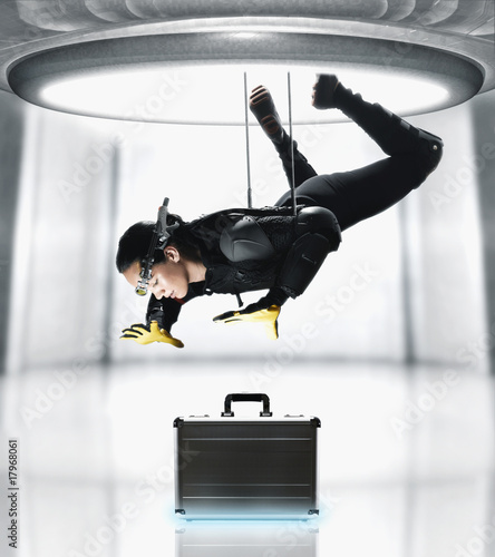Photo: Pacific Islander female spy suspended over briefcase Pacific Islander female spy suspended over briefcase