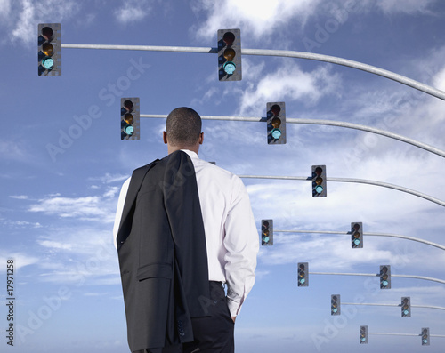 Photo: African businessman standing under traffic lights African businessman standing under traffic lights
