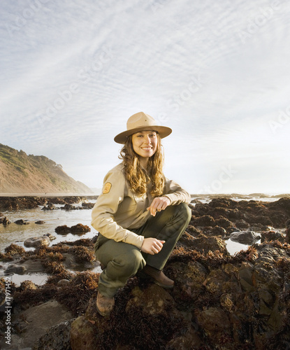 Photo: Mixed Race female park ranger next to tide pools Mixed Race female park ranger next to tide pools