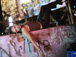 Young woman laying on wall covered in graffiti