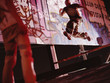 Young man jumping near graffitied wall