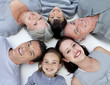 Foto: High angle of family lying on floor with heads together High angle of family lying on floor with heads together