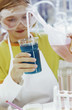 Photo: Girl (8-9) in chemical lab looking at test tube rack Girl (8-9) in chemical lab looking at test tube rack