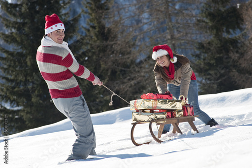 Foto: Couple with sleigh and presents in winter scene Couple with sleigh and presents in winter scene