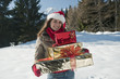 Young woman with Christmas presents in winter scene