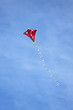 Ein roter Drachen mit gelbem Schweif hoch am Himmel