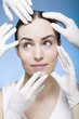 many rubber gloves touching the face of a young woman