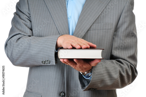 Photo: Hand on a book isolated on white background Hand on a book isolated on white background