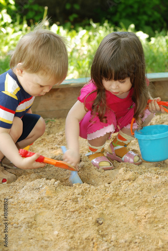 Photo: The boy and girl playing to a sandbox The boy and girl playing to a sandbox