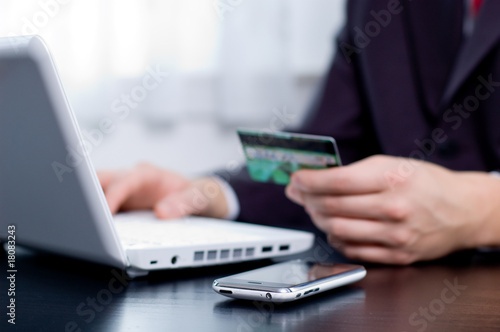 Foto: Businessman using his credit card for an online transaction Businessman using his credit card for an online transaction