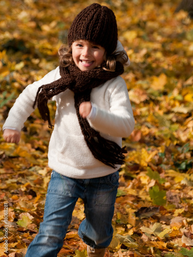 Foto: Happy girl running in autumn park Happy girl running in autumn park
