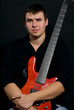 Portrait of young  man holding bass guitar - isolated on black