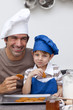 Father and son eating biscuits in the kitchen
