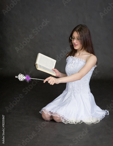 Photo: Girl - fairy with magic wand and book in hands Girl - fairy with magic wand and book in hands