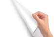 Photo: A hand is turing a white piece of paper A hand is turing a white piece of paper