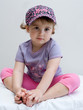 bambina seduta con vestito colorato