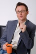 Photo: businessman with a cup of coffee looking at camera businessman with a cup of coffee looking at camera