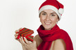 The beautiful girl smiles in a New Year's cap hoding a present The beautiful girl smiles in a New Year's cap hoding a present
