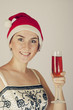 smiling woman in a New Year's cap hoding with glass of red wine smiling woman in a New Year's cap hoding with glass of red wine