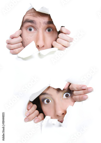 Photo: couple peeping through hole in white paper couple peeping through hole in white paper