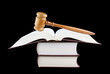 Judge's gavel and stack of legal books isolated on black