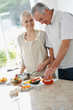 Smiling old aged couple cooking food together Smiling old aged couple cooking food together