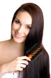 Young beautiful woman brushing her long healthy hair