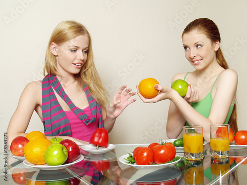Foto: Two girls with vegetables and fruit Two girls with vegetables and fruit