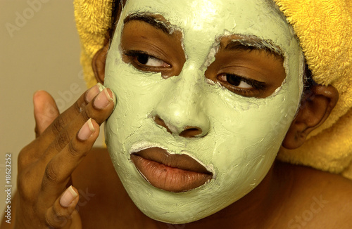Photo: Woman putting on a facial mask Woman putting on a facial mask