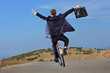 Carefree businessman holding a briefcase and riding a bicycle Carefree businessman holding a briefcase and riding a bicycle