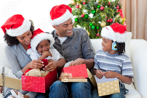 Foto: Happy Afro-American family opening Christmas presents Happy Afro-American family opening Christmas presents
