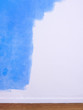 White interior wall partially covered with blue paint.