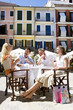 Couples laughing at sunny, outdoor caf